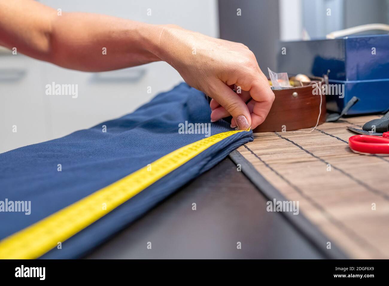 Female lavoro su un abbigliamento cucito cucitura misurazione con misuratore giallo Foto Stock