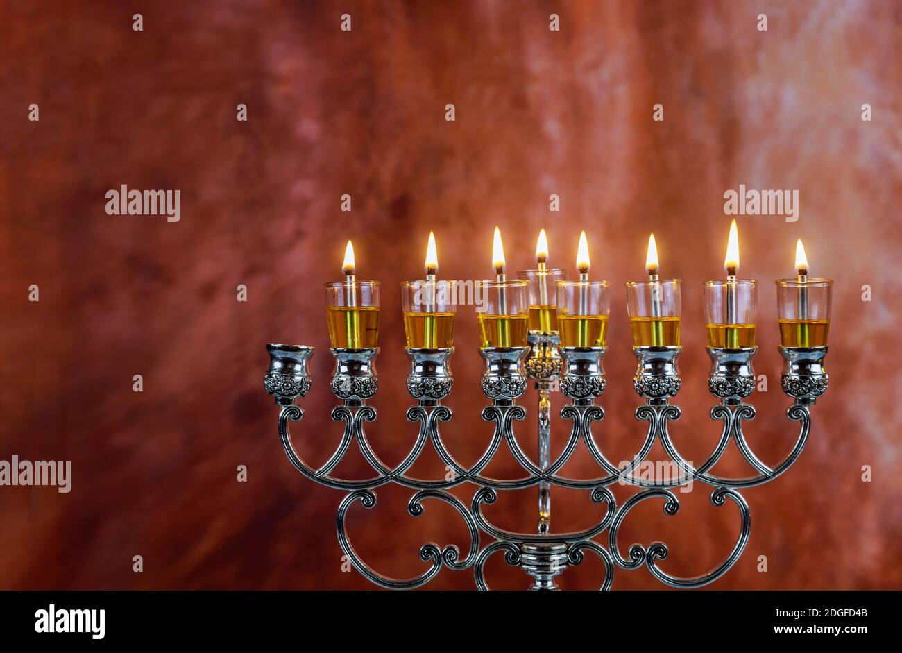 Le candele di Menorah Hanukkah stanno bruciando in hanukkiah sulla luce sette giorni di festa. Foto Stock