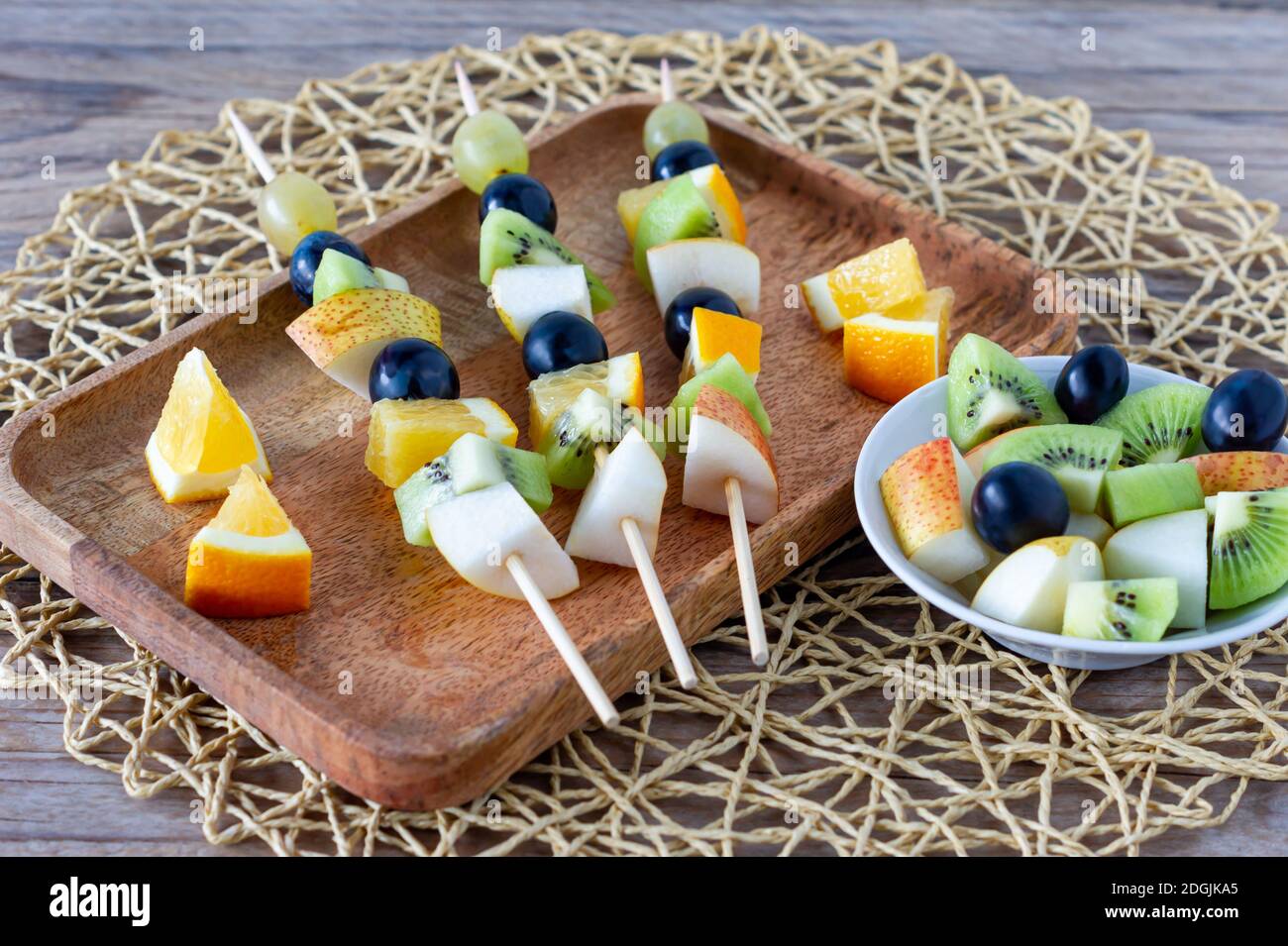 Tartine di frutta per un buffet su un piatto. Miscela di mandarino, mela, kiwi, uva, banana Foto Stock