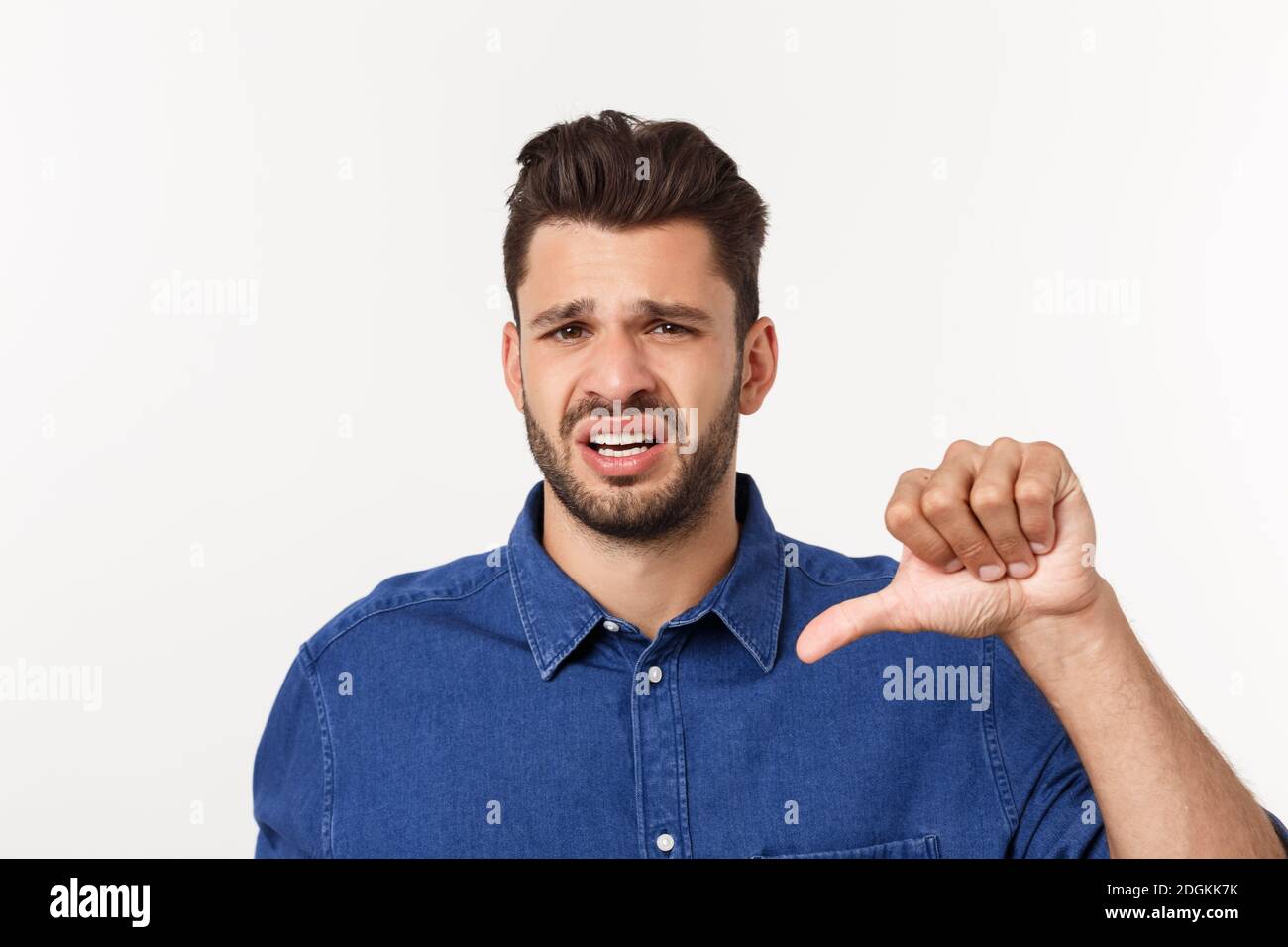 Primo piano ritratto di deluso sottolineato ragazzo bearded in camicia su sfondo bianco. Foto Stock