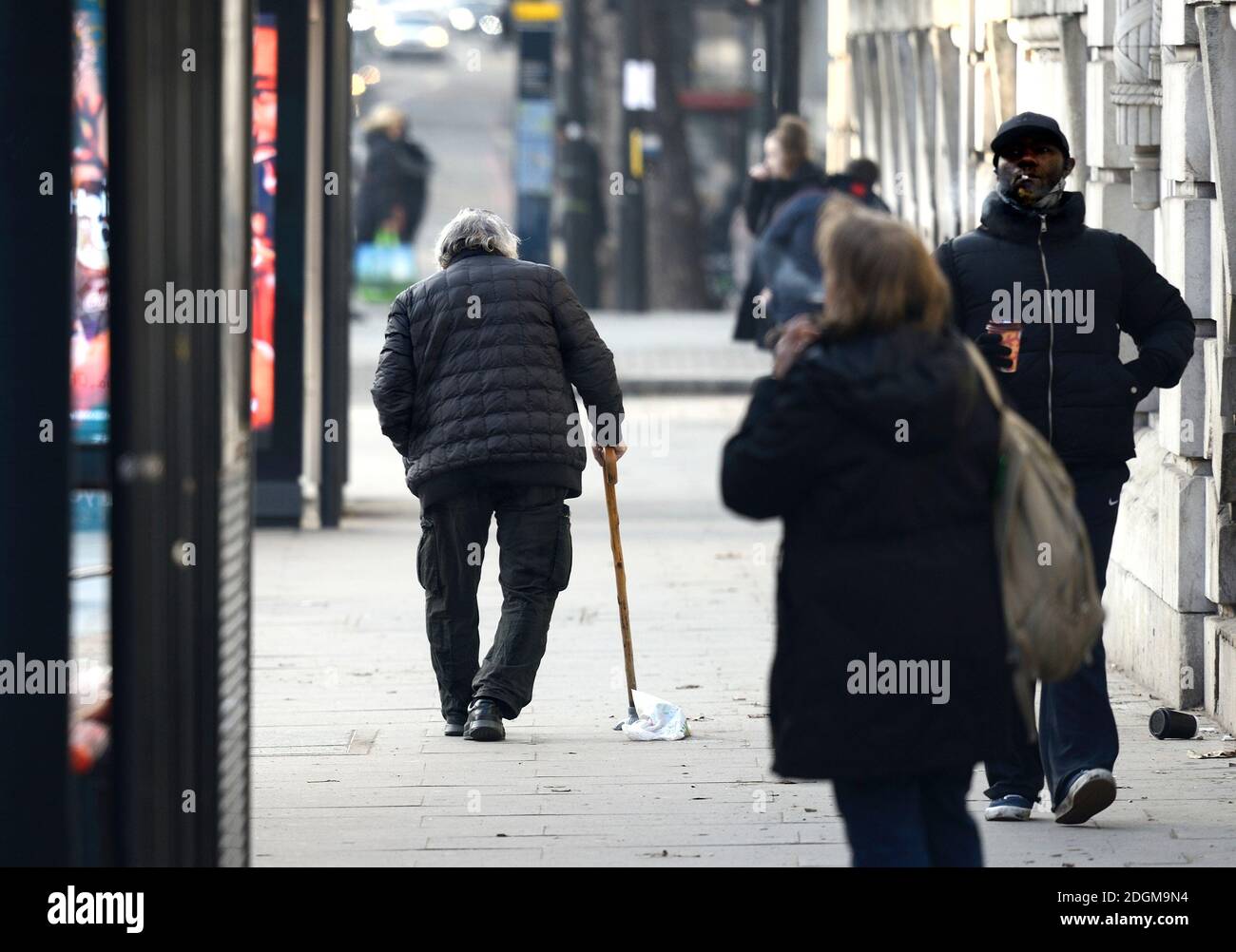 Londra, Inghilterra, Regno Unito. Uomo anziano con gambe a gomito e un bastone a piedi in Marylebone Road Foto Stock