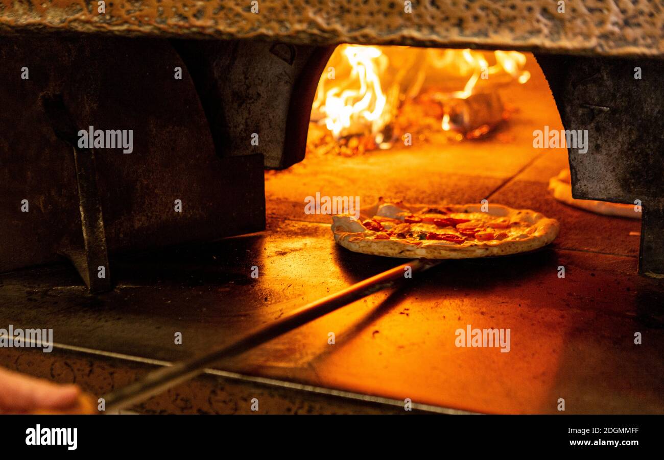 Una pizza è messa in un forno a legna in Un ristorante a Roma Foto stock -  Alamy