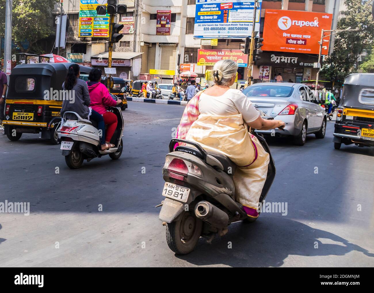 PUNE, INDIA - 14 MARZO 2019: Donne sui ciclomotori su una strada trafficata in Pune, Maharashtra di stato, India Foto Stock