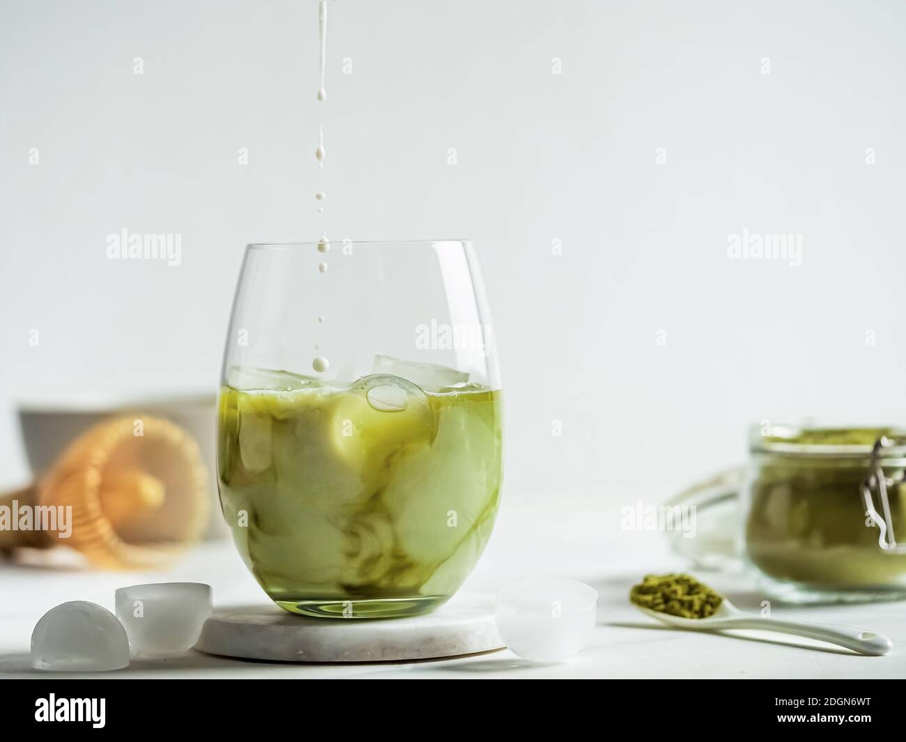 Tè Matcha latte ghiacciato con gocce di latte Foto Stock