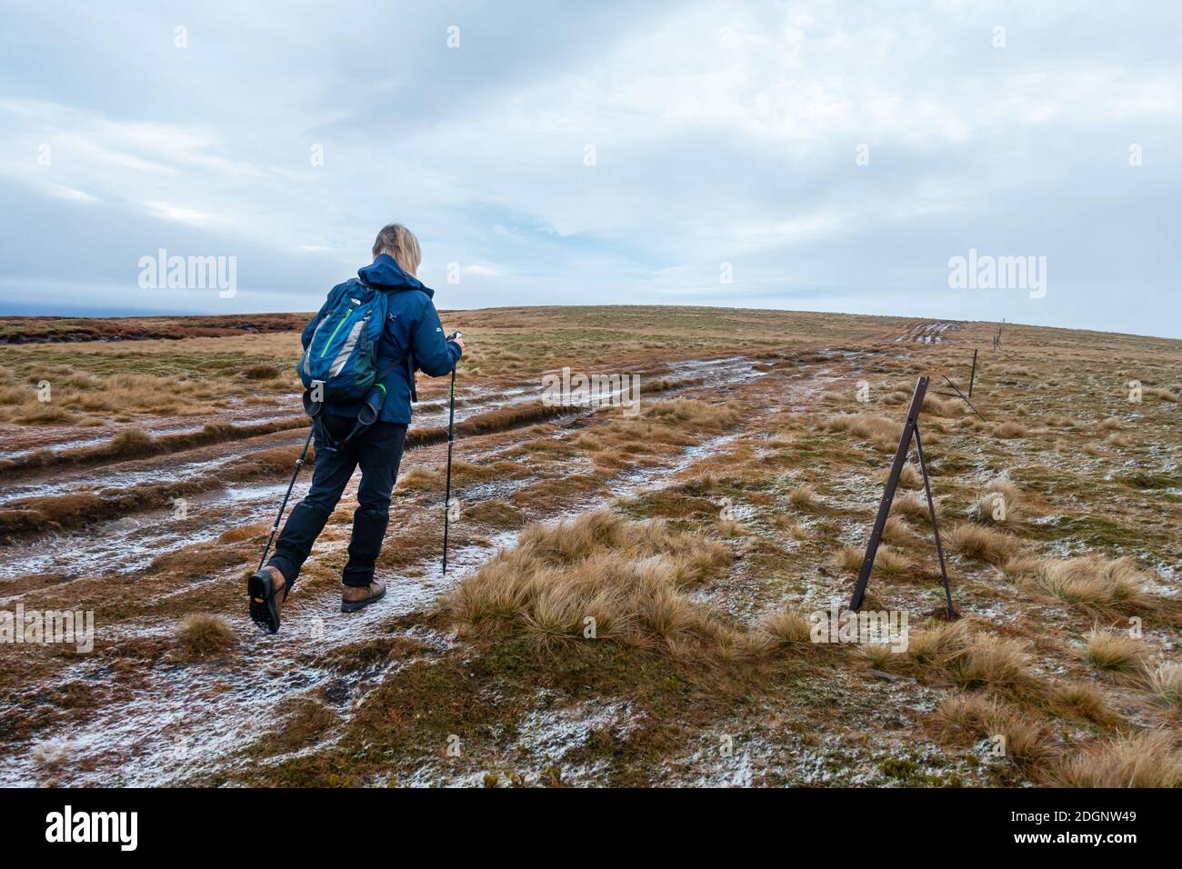 Un camminatore segue la linea di pali di recinzione fino alla montagna Munro di Carn Na Caim nel Passo di Drumochter vicino a Dalwhinnie, Scozia, Regno Unito Foto Stock