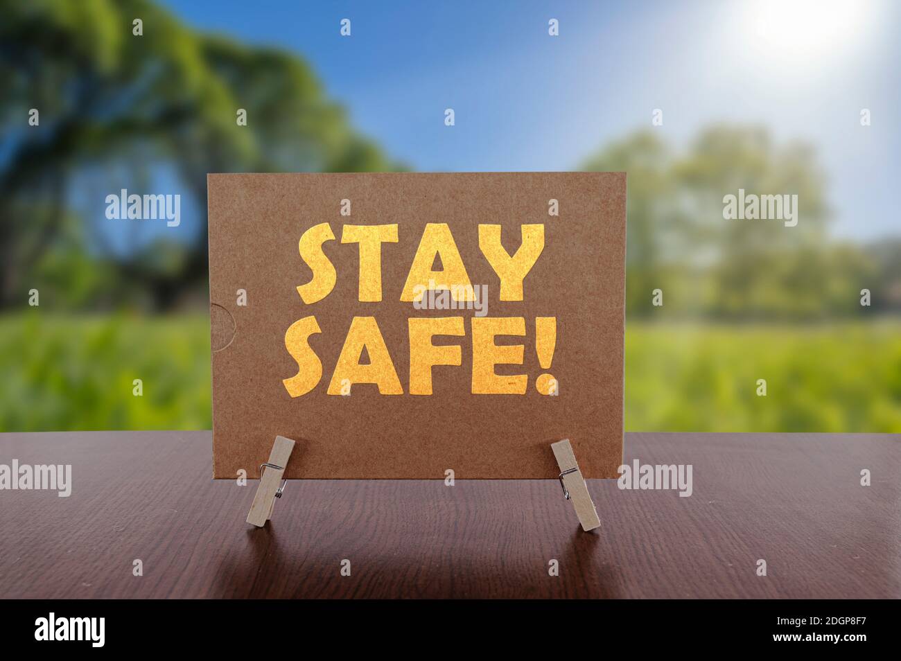 Testo sicuro sulla carta sul tavolo con sfondo verde soleggiato del parco. Foto Stock