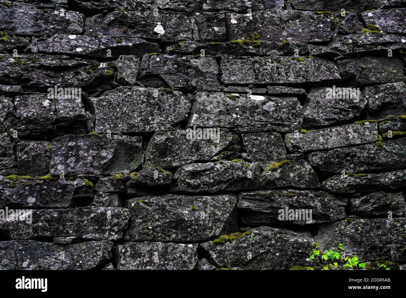 Mura medievali in pietra e architettura ad arco realizzata con rocce di granito ruvide. Primo piano. Foto Stock