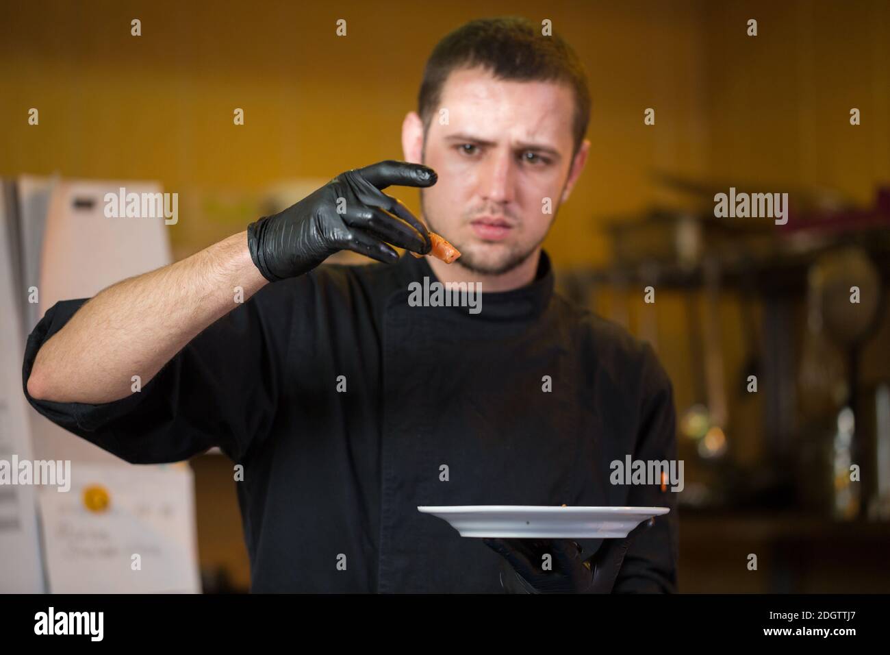 La cucina a tema è la professione di cucina. Ritratto di uomo caucasico in cucina ristorante preparazione di filetti di pesce rosso carne di salmone i Foto Stock
