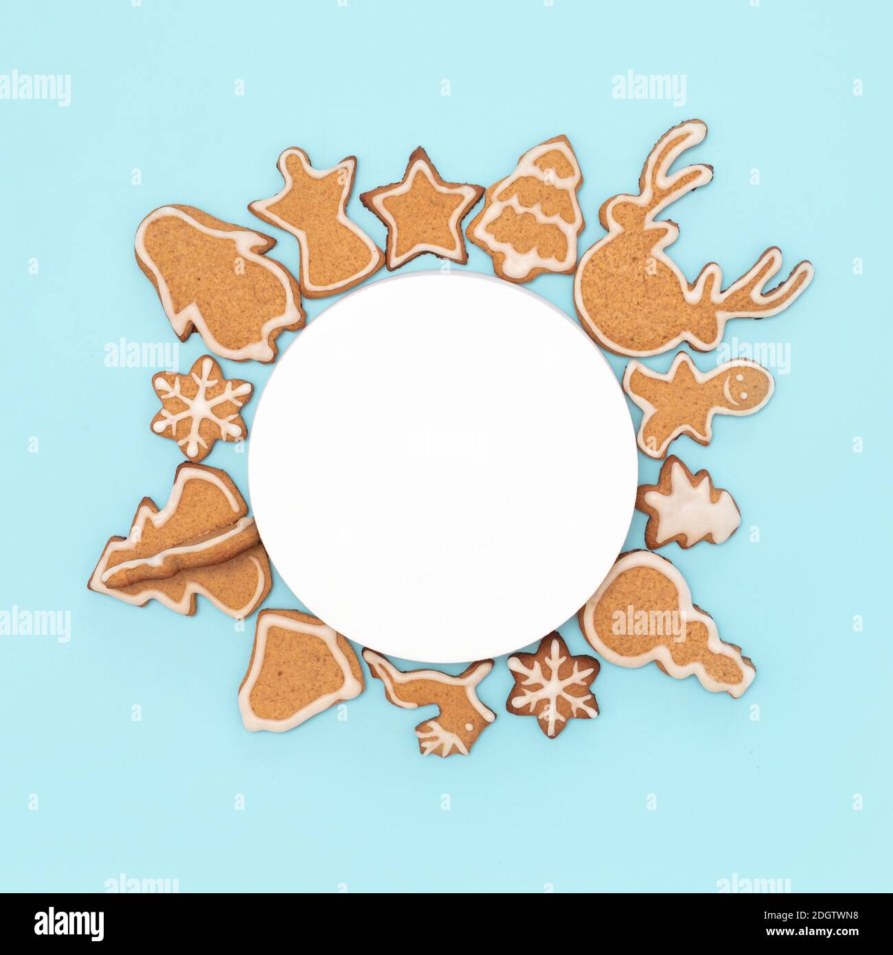 Ornamento natalizio con biscotti di pan di zenzero. Spazio cerchio vuoto per testo e biscotti natalizi su tela, in posizione piana o vista dall'alto. Cottura di Natale su sfondo blu Foto Stock