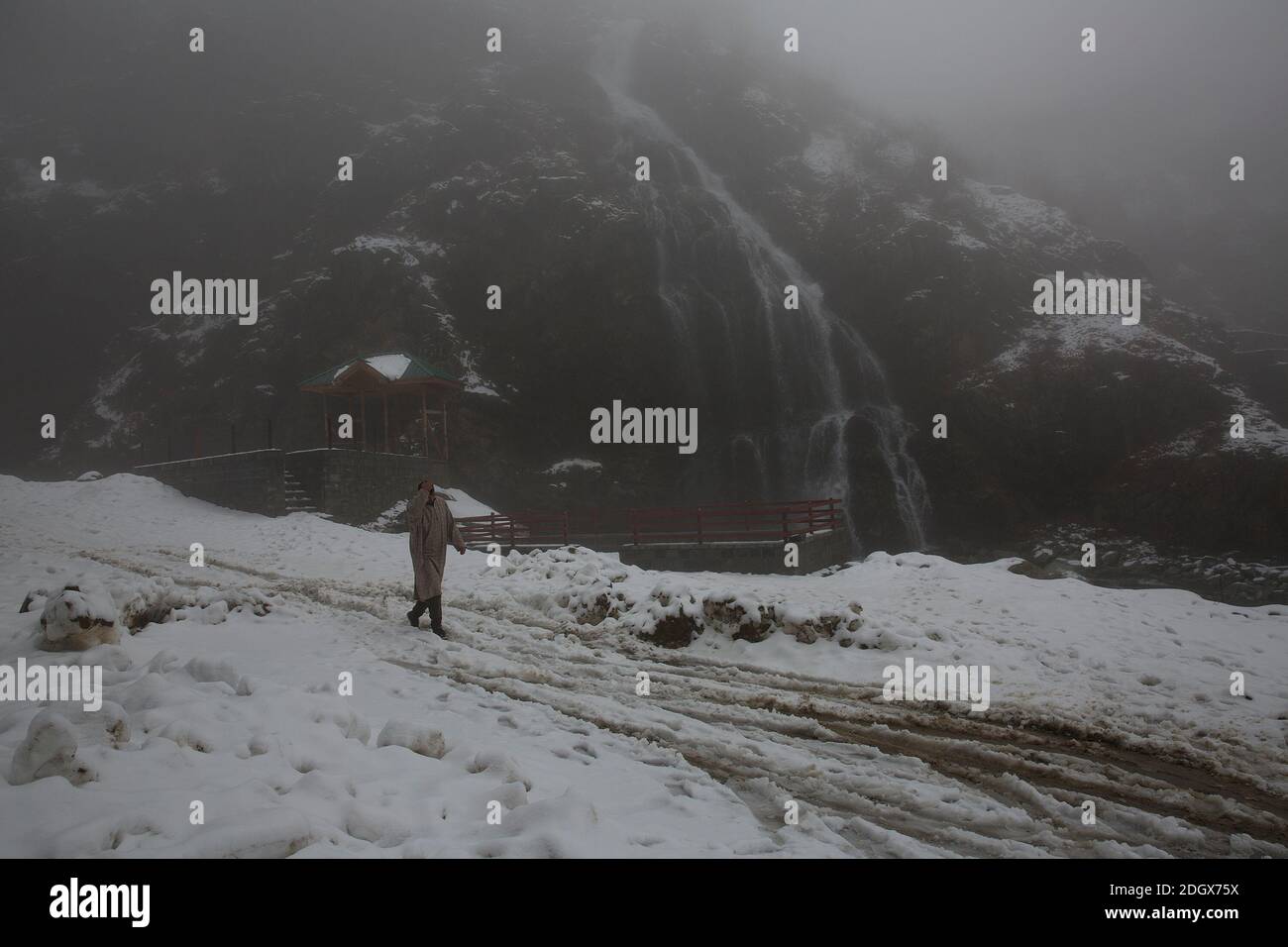 Srinagar, Kashmir. 9 Dic 2020. Un uomo cammina tra la nebbia dopo una fresca nevicata in un villaggio nel quartiere di Baramulla vicino alla città di Srinagar, la capitale estiva di Kashmir, 9 dicembre 2020. Credit: Javed Dar/Xinhua/Alamy Live News Foto Stock
