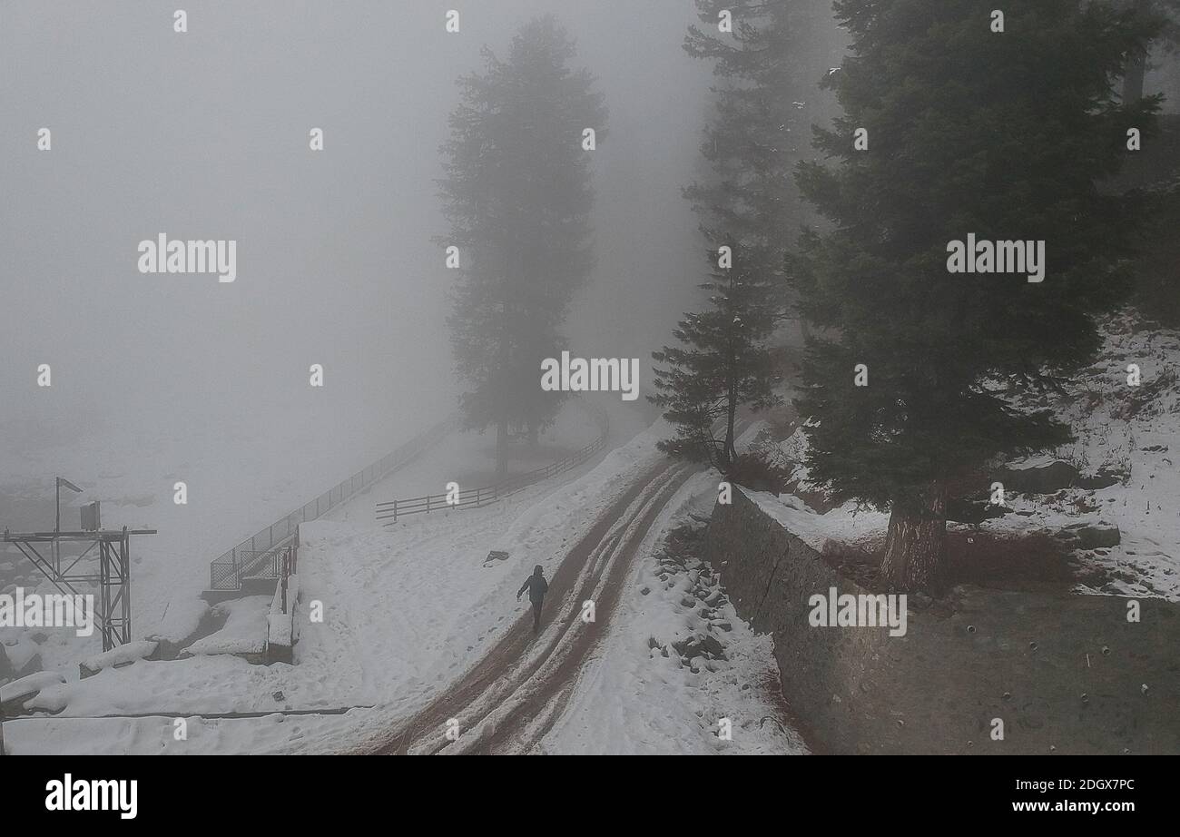 Srinagar, Kashmir. 9 Dic 2020. Una ragazza cammina in mezzo alla nebbia dopo una fresca nevicata in un villaggio nel quartiere di Baramulla vicino alla città di Srinagar, la capitale estiva di Kashmir, 9 dicembre 2020. Credit: Javed Dar/Xinhua/Alamy Live News Foto Stock