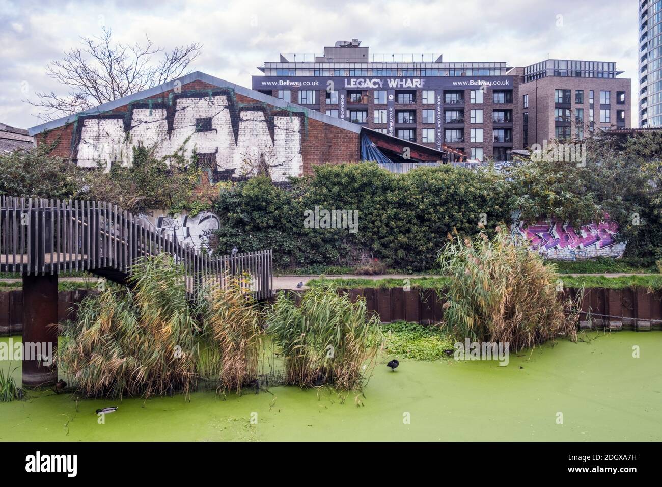 Londra, Newham, Stratford. Fiume Lea. Warehousing derelict, terreno brownfield, sviluppo di banchina legacy intorno al canale del fiume Lea. Acqua inquinata e stagnante Foto Stock