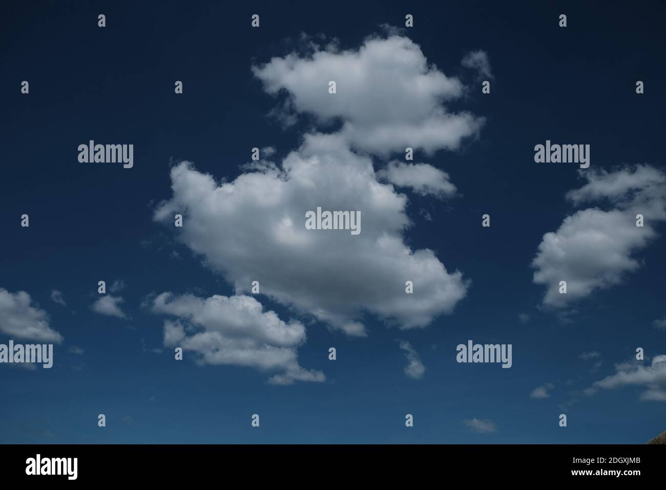 Definite nuvole bianche su un cielo blu profondo Foto Stock