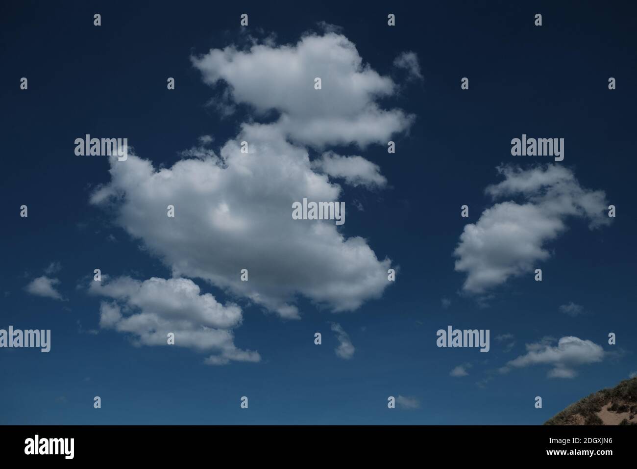 Definite nuvole bianche su un cielo blu profondo Foto Stock