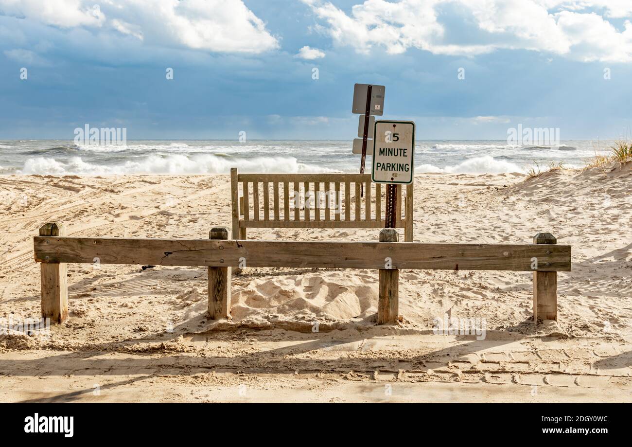 Panca di legno e segni con oceano sullo sfondo a Town Line Beach, wainsscott, NY Foto Stock