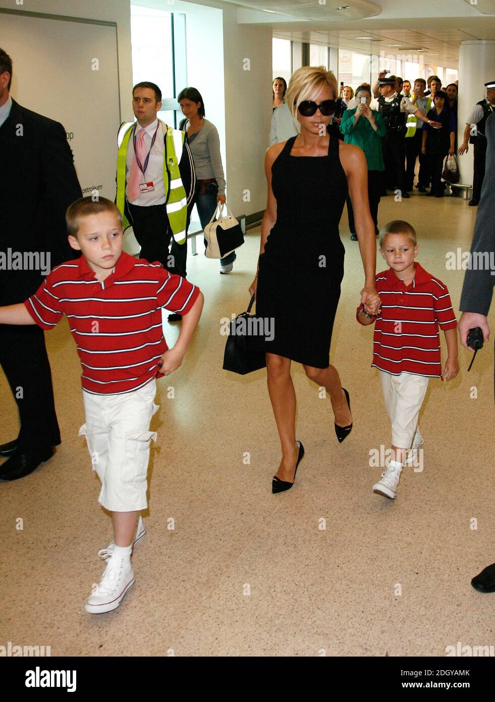 Victoria Beckham ha ritratto con i suoi figli Brooklyn e Romeo a Heathrow mentre parte per Los Angeles per vedere suo marito unirsi alla squadra di calcio LA Galaxy. Foto Stock