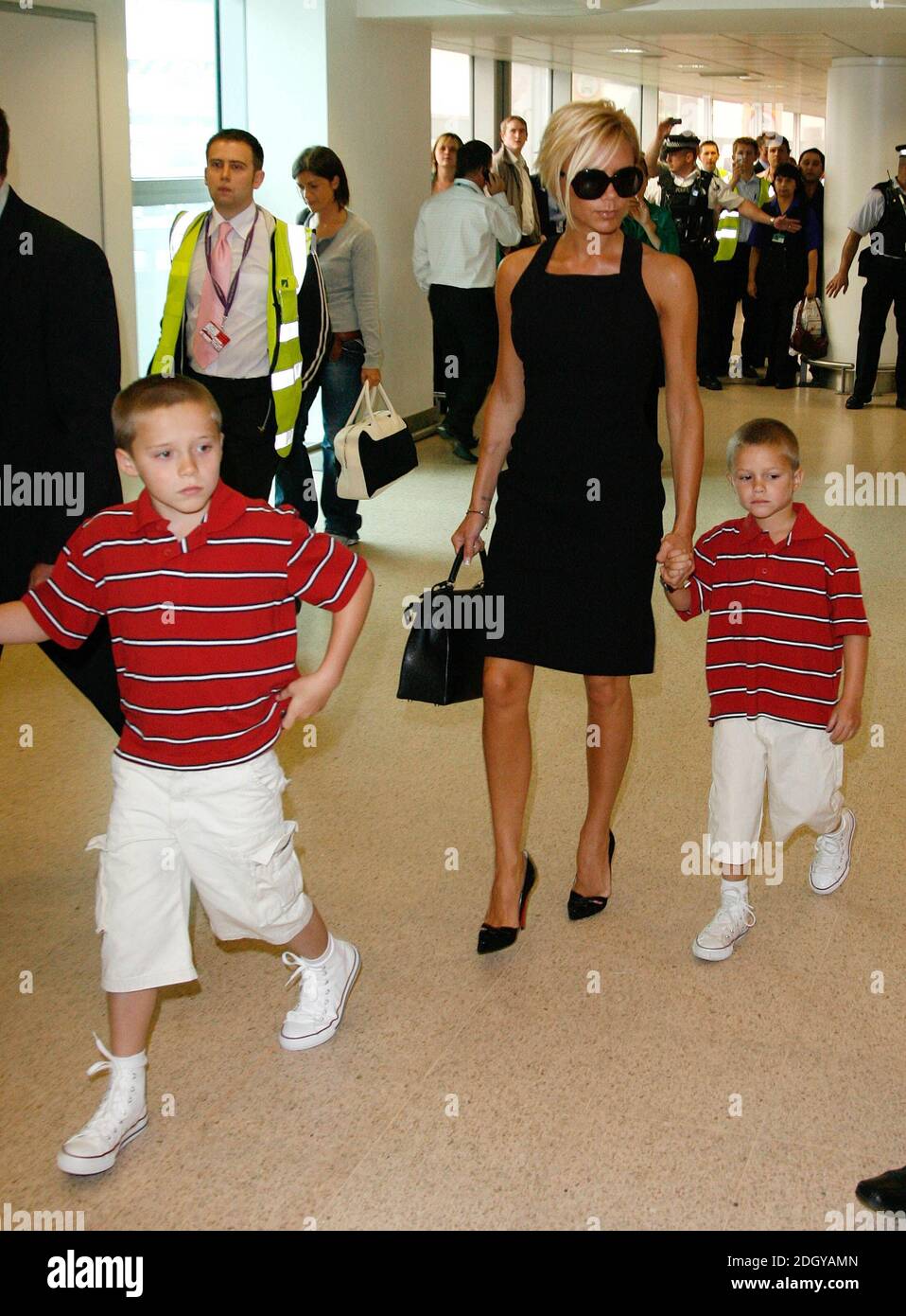 Victoria Beckham ha ritratto con i suoi figli Brooklyn e Romeo a Heathrow mentre parte per Los Angeles per vedere suo marito unirsi alla squadra di calcio LA Galaxy. Foto Stock