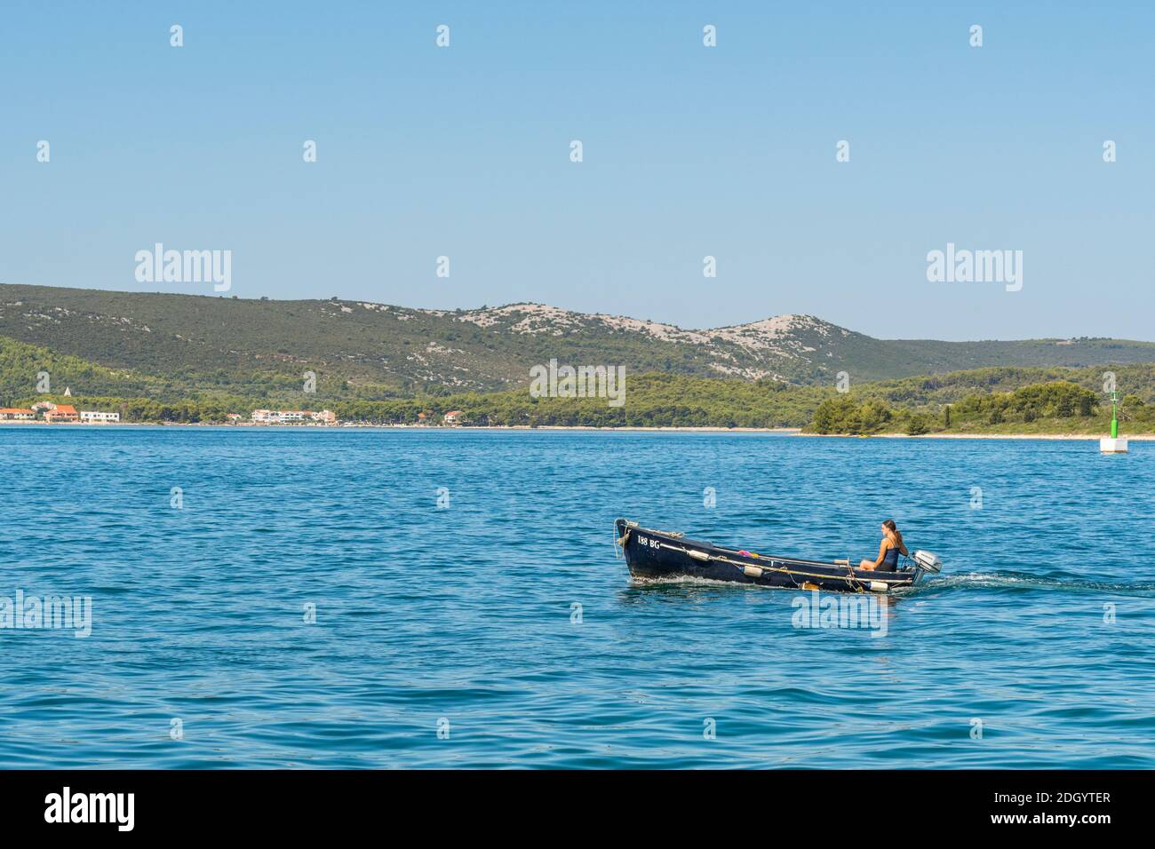 Vista dell'isola di Pašman, marinaio in una piccola barca a motore, dalla costa dalmata, Croazia, sul mare Adriatico. Foto Stock