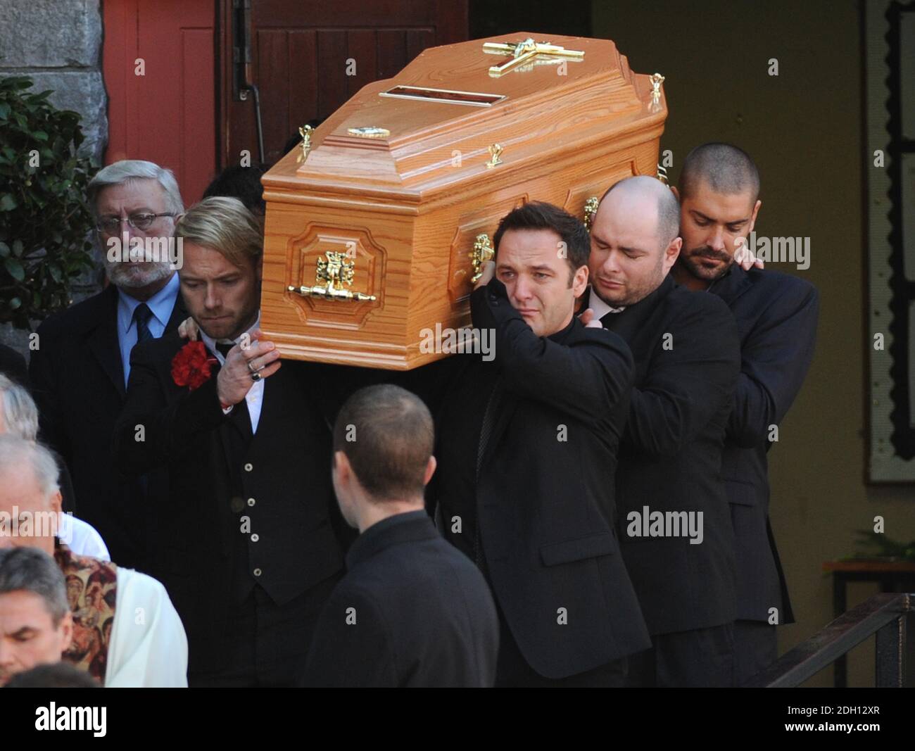 La bara è portata fuori dalla chiesa da Ronan Keating, Mikey Graham, Keith Duffy e Shane Lynch al funerale di Stephen Gately a St Laurence o'Toole Church, Sevilla Place, Dublino Foto Stock