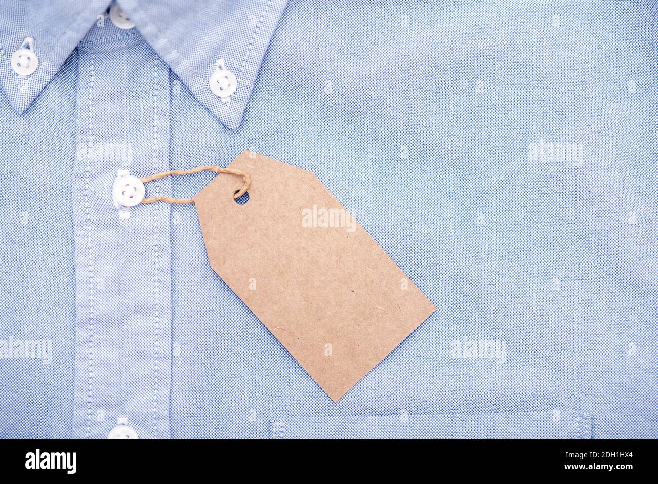 Etichetta di carta vuota o etichetta sulla parte superiore della camicia blu, spazio per il testo Foto Stock