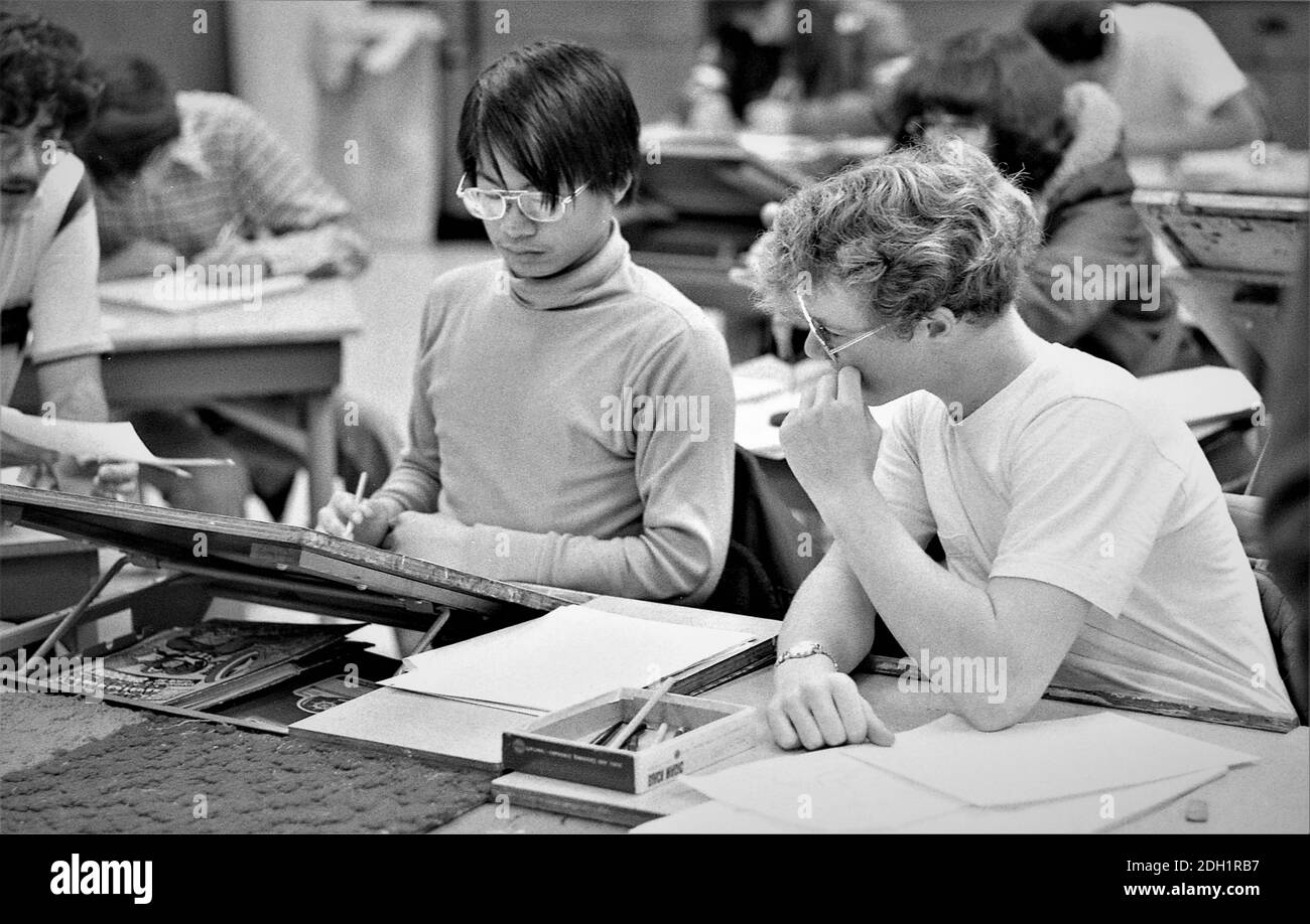 Gli studenti delle scuole superiori etniche in classe d'arte che svolgono compiti insieme essendo cooperativi; sia le ragazze che i ragazzi che sono adolescenti Foto Stock