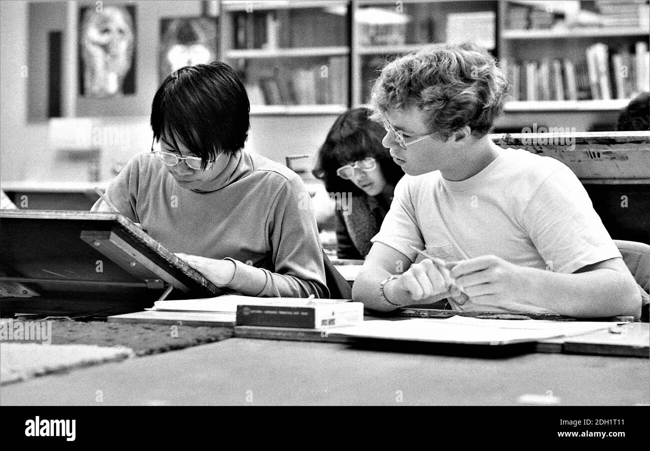 Gli studenti delle scuole superiori etniche in classe d'arte che svolgono compiti insieme essendo cooperativi; sia le ragazze che i ragazzi che sono adolescenti Foto Stock