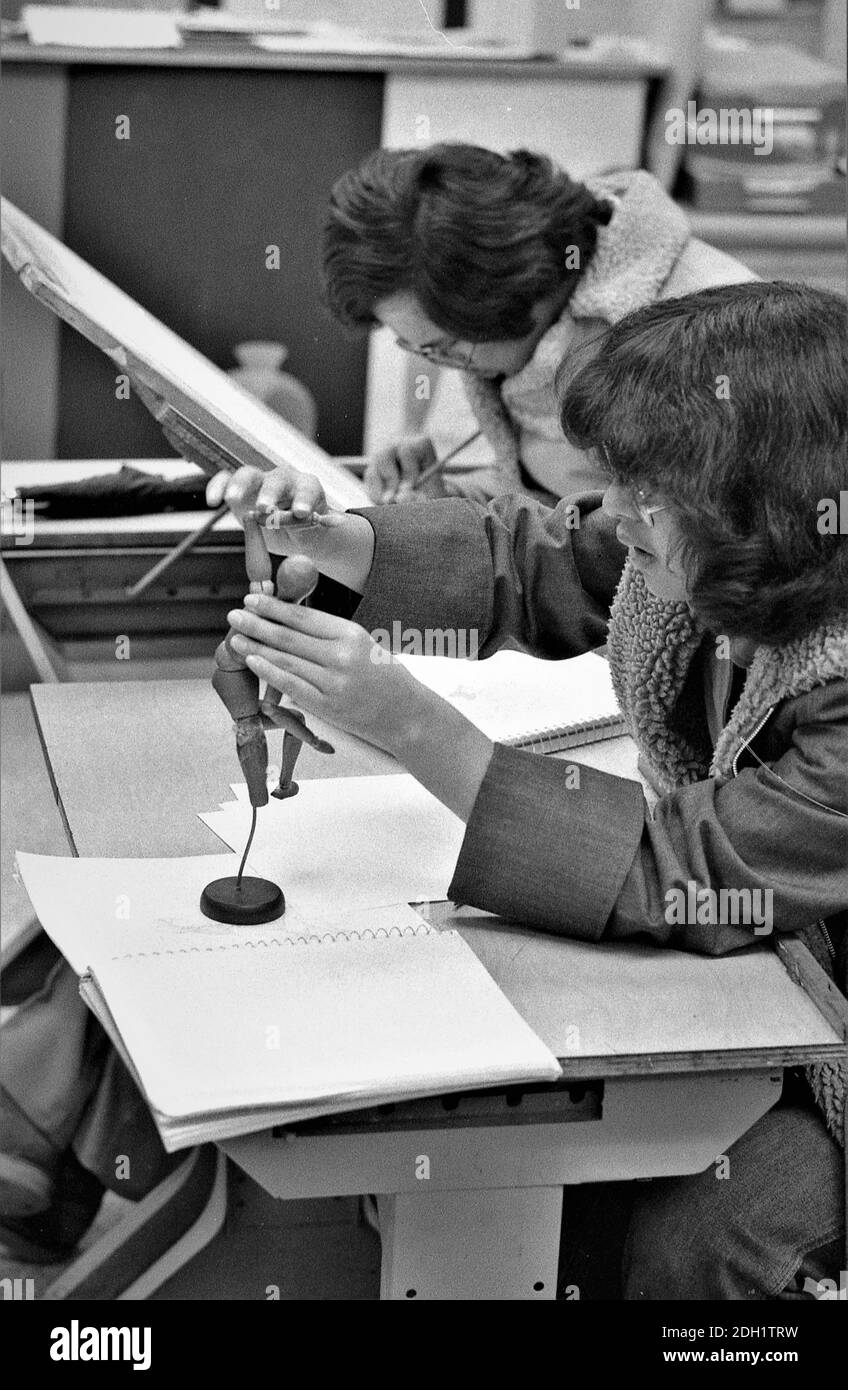 Gli studenti delle scuole superiori etniche in classe d'arte che svolgono compiti insieme essendo cooperativi; sia le ragazze che i ragazzi che sono adolescenti Foto Stock