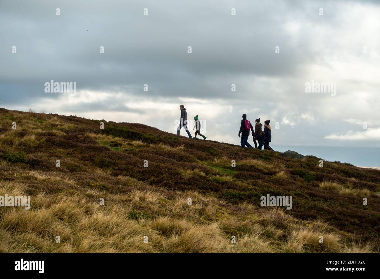Famiglia con bambini che camminano nella campagna della brughiera godendo i grandi spazi aperti, Burley Moor, Ilkley, West Yorkshire, Inghilterra, Regno Unito Foto Stock