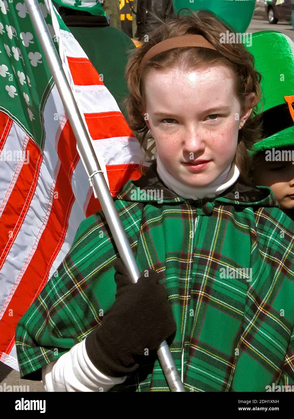 Teen Femminile Marches con bandiera di St. Paddys nella Parata di San Patrizio Foto Stock