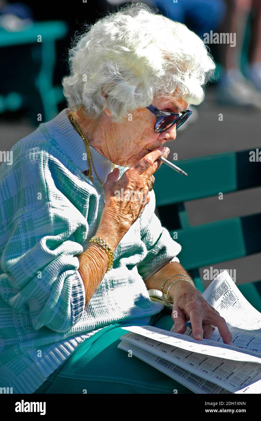 donna anziana che fuma una sigaretta all'esterno Foto Stock