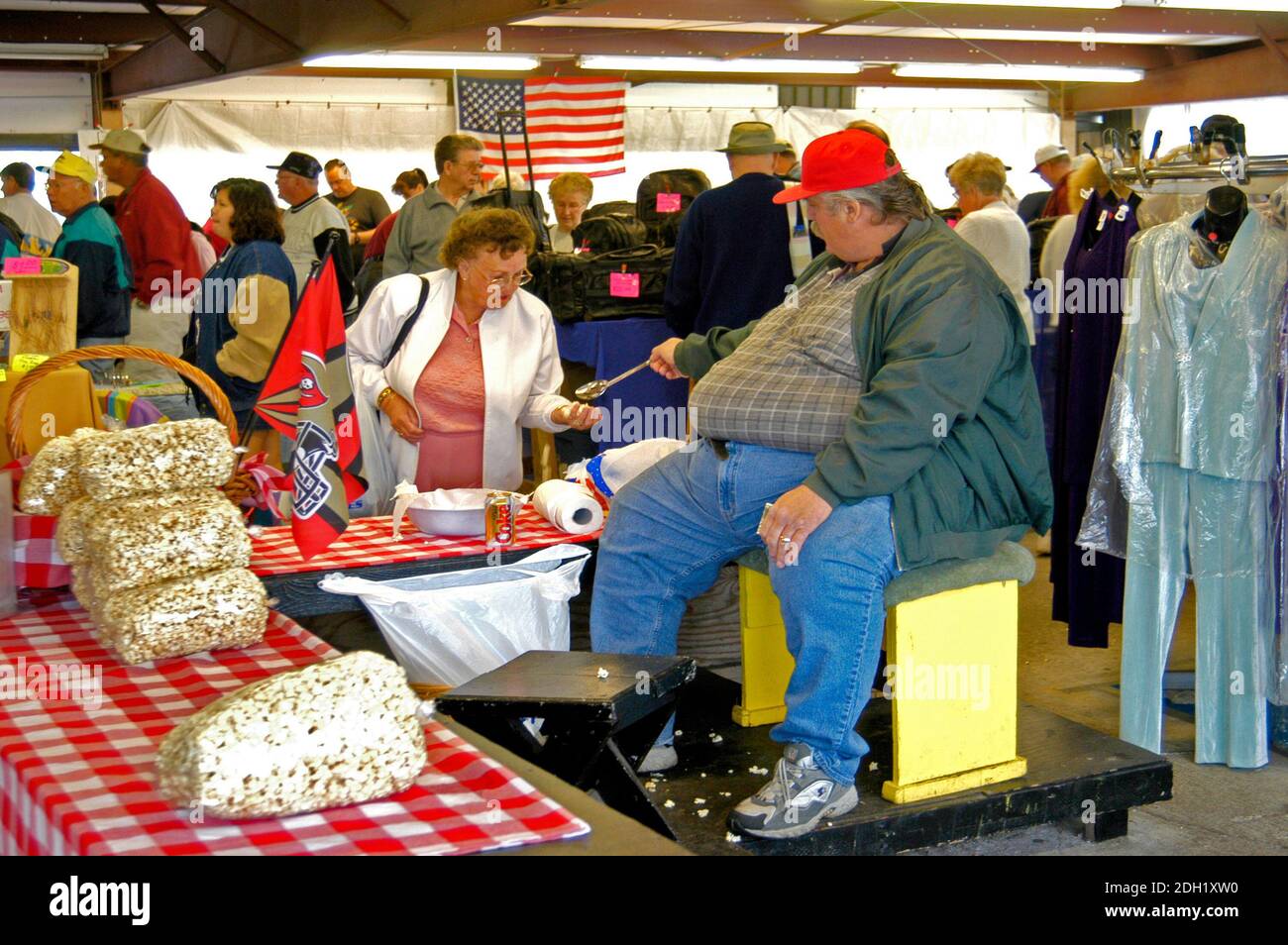 Uomo davvero grasso che vende popcorn ad un mercato all'aperto Foto Stock