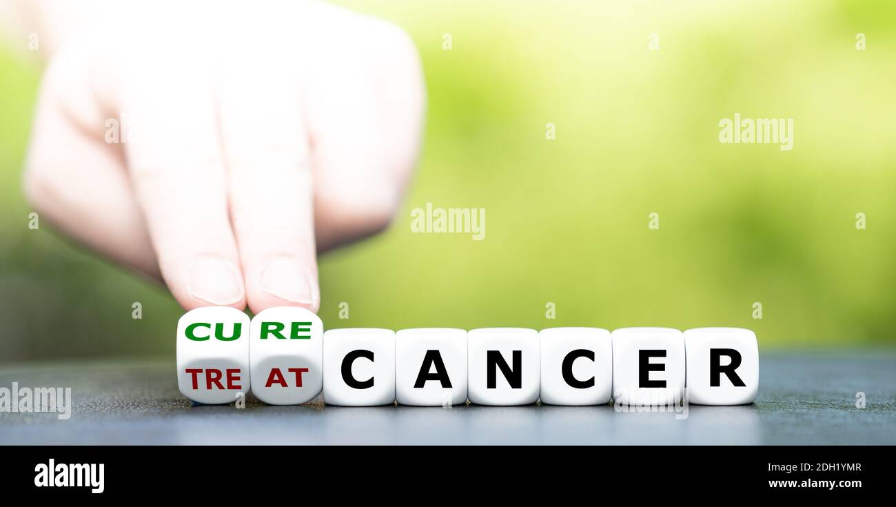 La mano trasforma i dadi e cambia l'espressione 'trattare il cancro' in 'curare il cancro'. Foto Stock