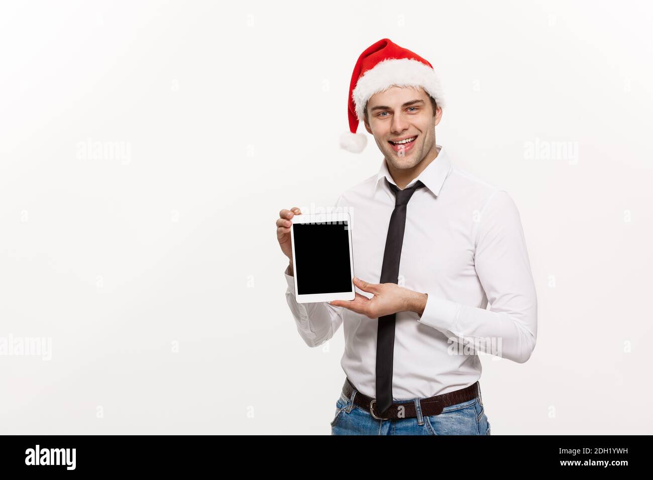 Natale concetto - bello uomo di affari presenta qualcosa sul mobile schermo celebrare buon natale e felice anno nuovo s usura Foto Stock