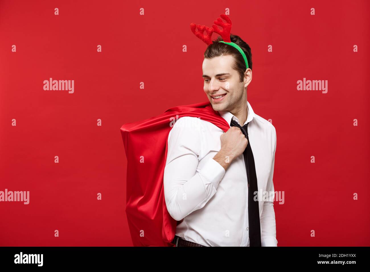 Natale concetto - bello uomo di affari celebrare buon natale e. Felice anno nuovo indossare renna fairband tenere Santa rosso Foto Stock