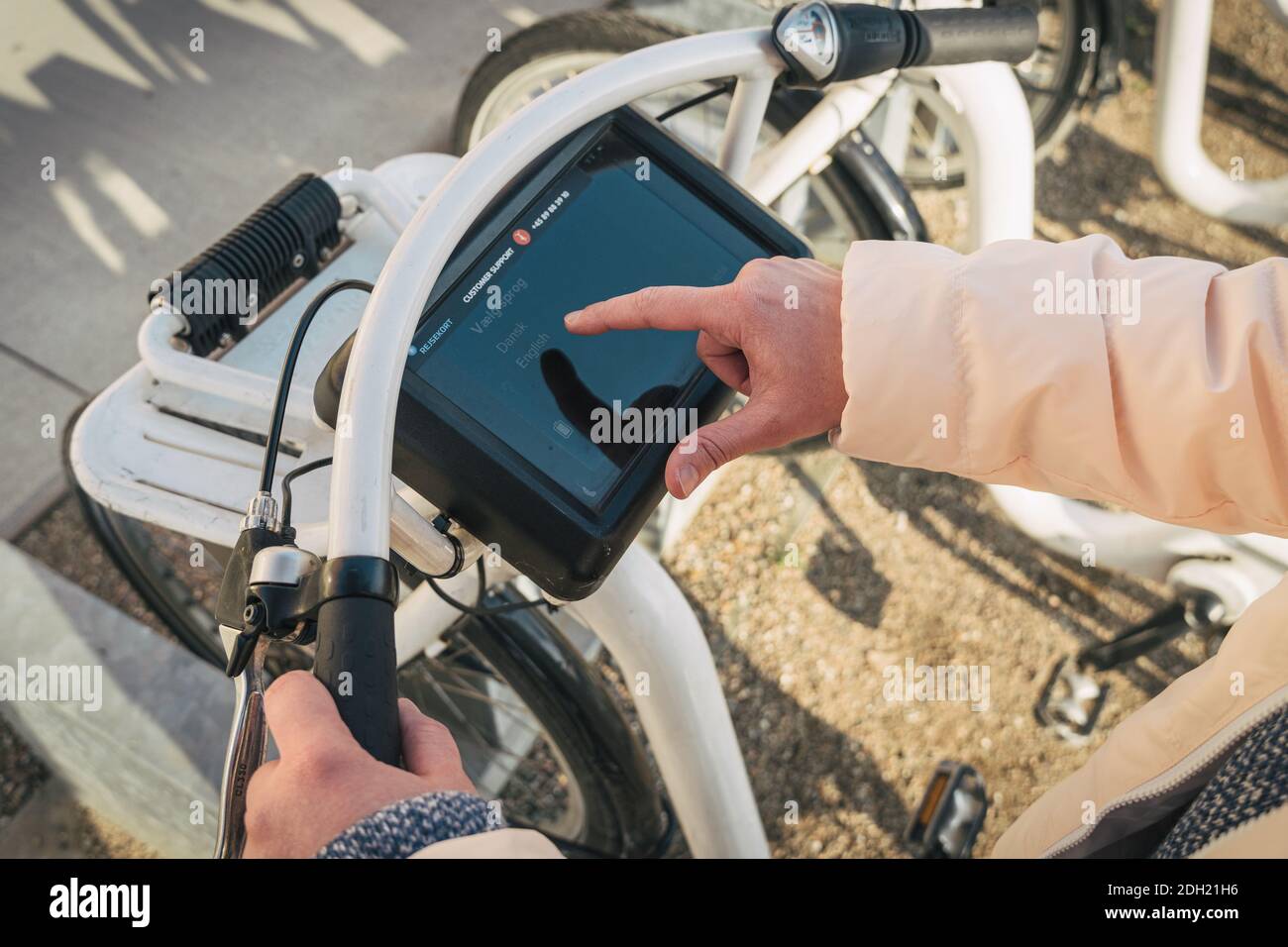 Ragazza noleggio bici da città da stand bici a Copenhagen, Danimarca 18 febbraio 2019. Bella donna che prende la bicicletta a noleggio. Felice Foto Stock