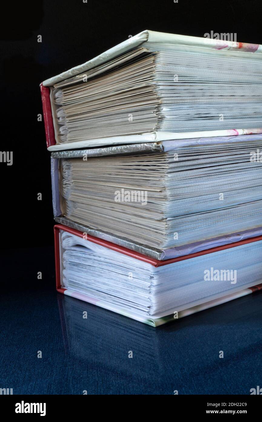 La pila dei libri poggia su turn blu il tavolo con riflessione. Soggetti su sfondo nero primo piano Foto Stock