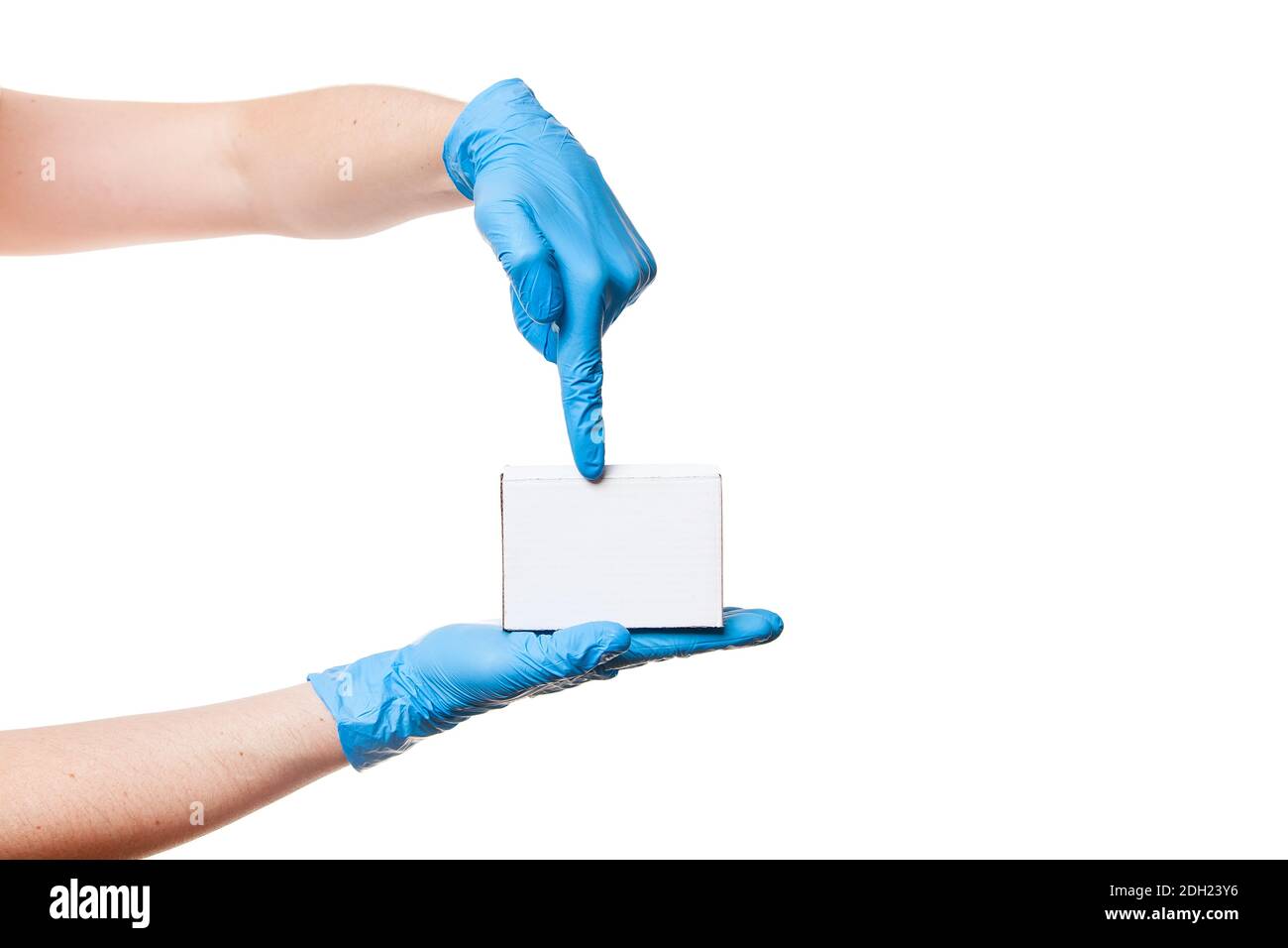 Consegna l'uomo mani in blu guanti sterili per uso medico tiene una scatola di cartone bianca sul palmo e mostra le dita, consegna sicura durante la quarantena rimanere a casa, Foto Stock