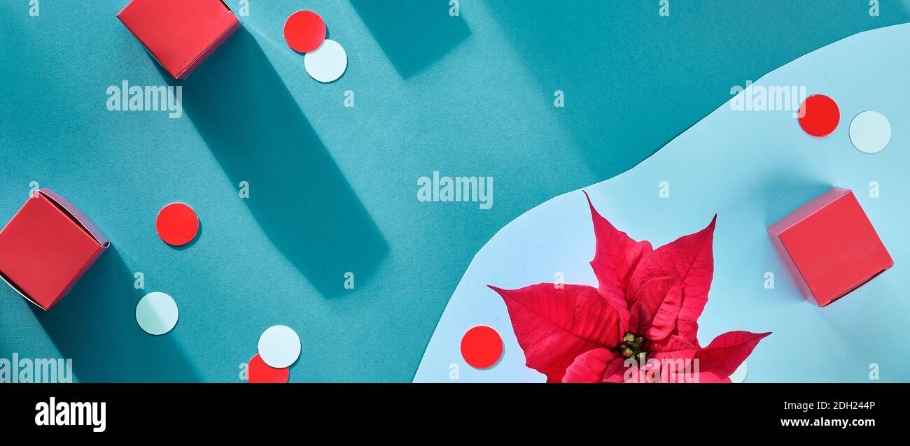 Rosso ciano sfondo panoramico di Natale.Vista dall'alto con fiore poinsettia, scatole regalo, cerchi di carta Foto Stock