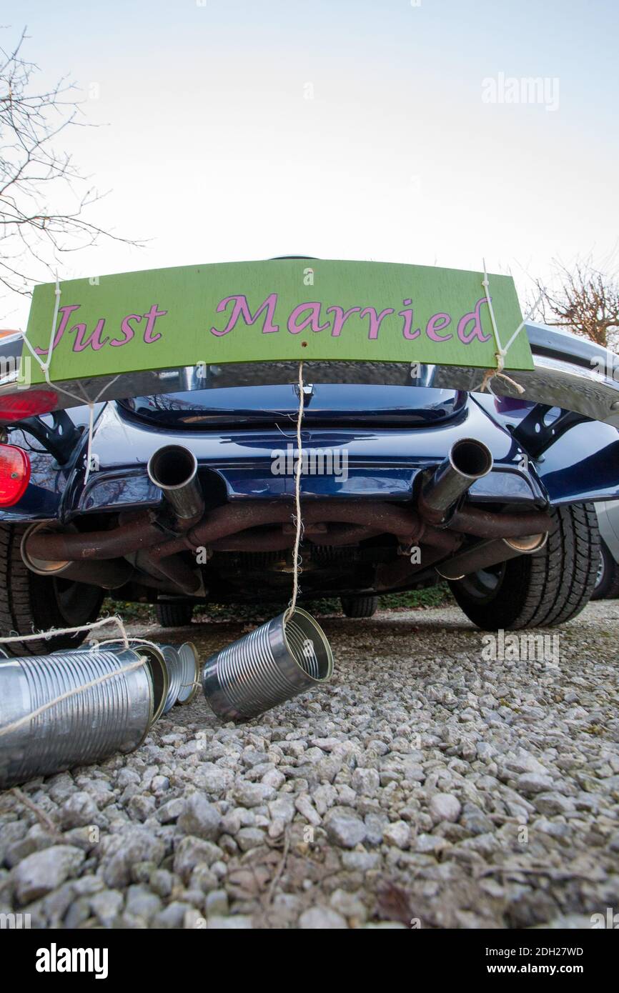 Vista posteriore di un'auto da matrimonio vintage appena sposata cartello e lattine attaccati Foto Stock