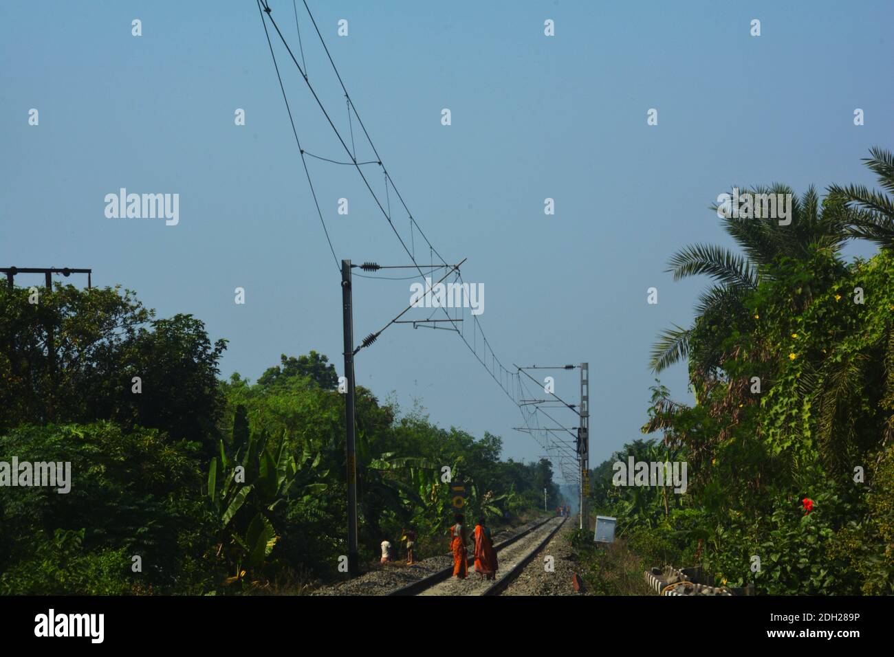 Primo piano delle linee ferroviarie e trazione elettrica aerea delle Ferrovie indiane che attraversano la campagna, focalizzazione selettiva Foto Stock