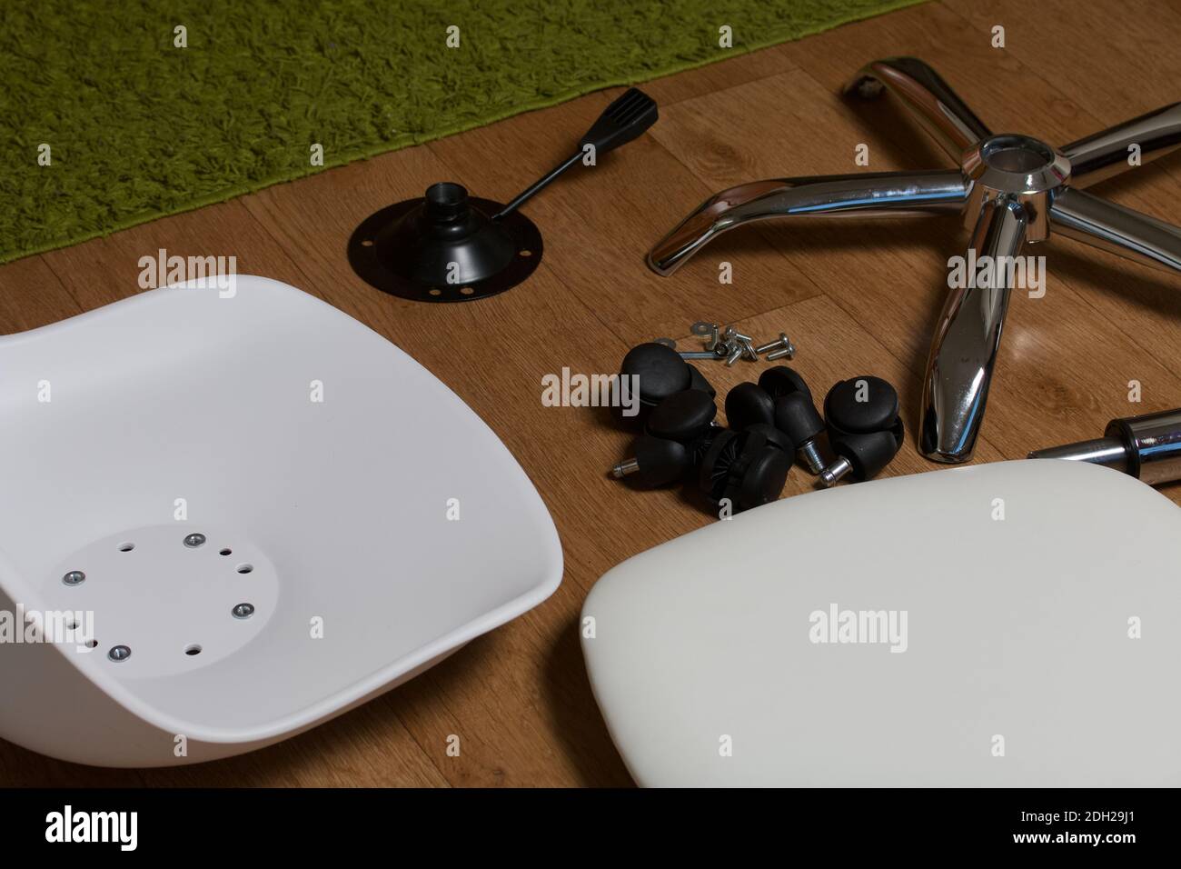 Dettagli della sedia da ufficio. Si trovano al piano dell'appartamento. Montaggio di una sedia per computer su ruote. Foto Stock