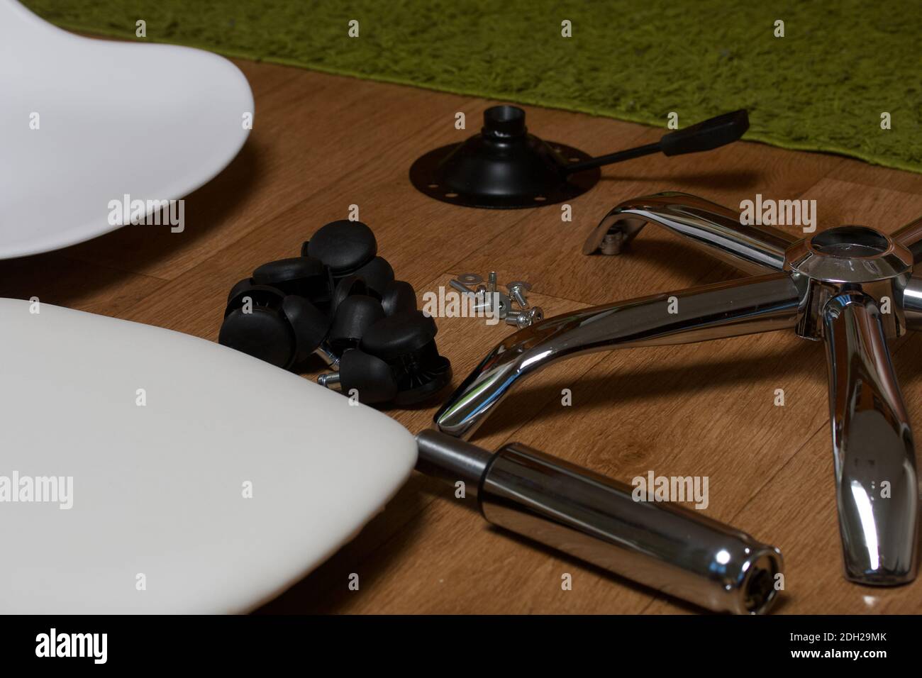 Dettagli della sedia da ufficio. Si trovano al piano dell'appartamento. Montaggio di una sedia per computer su ruote. Foto Stock