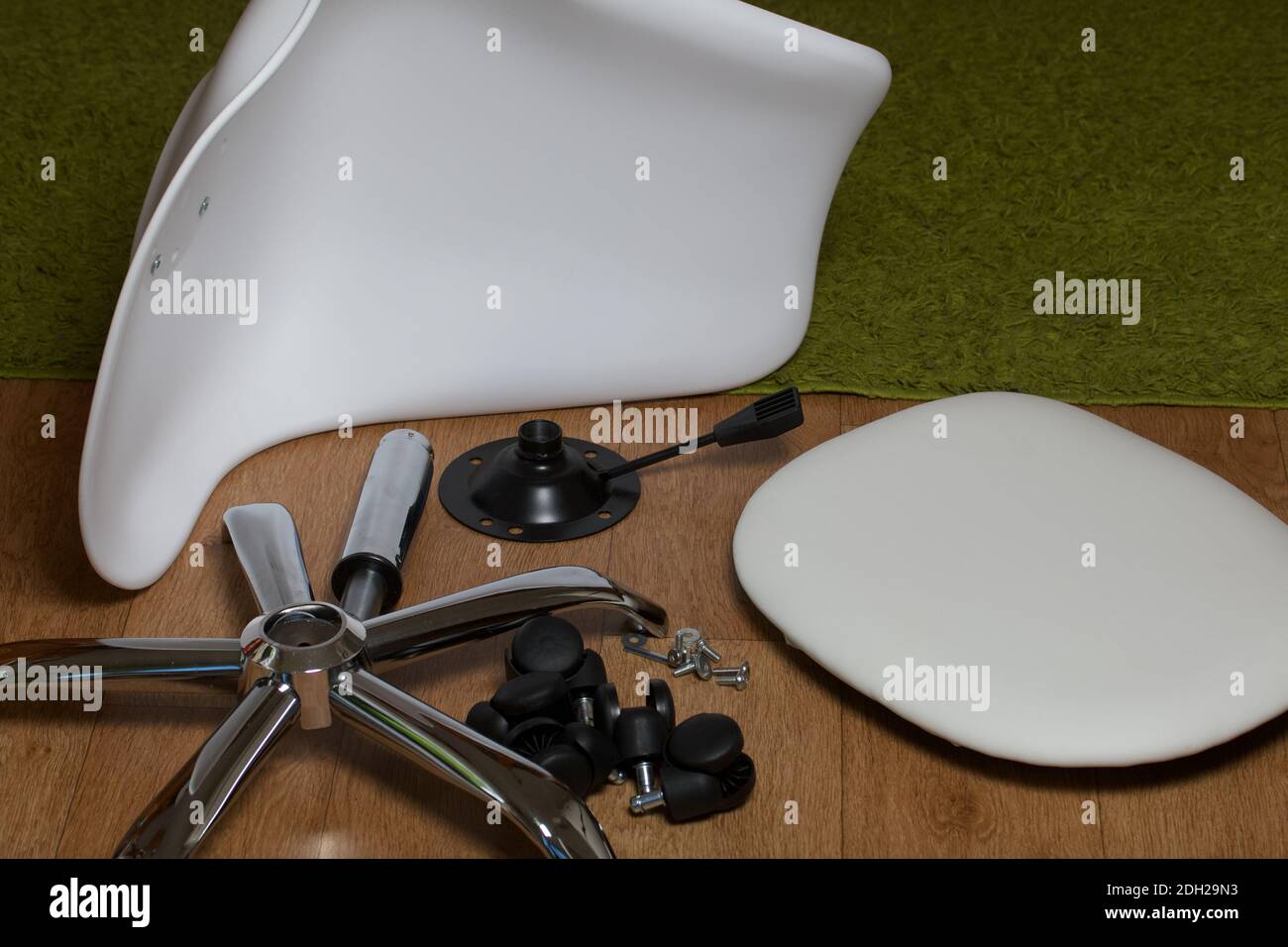 Dettagli della sedia da ufficio. Si trovano al piano dell'appartamento. Montaggio di una sedia per computer su ruote. Foto Stock