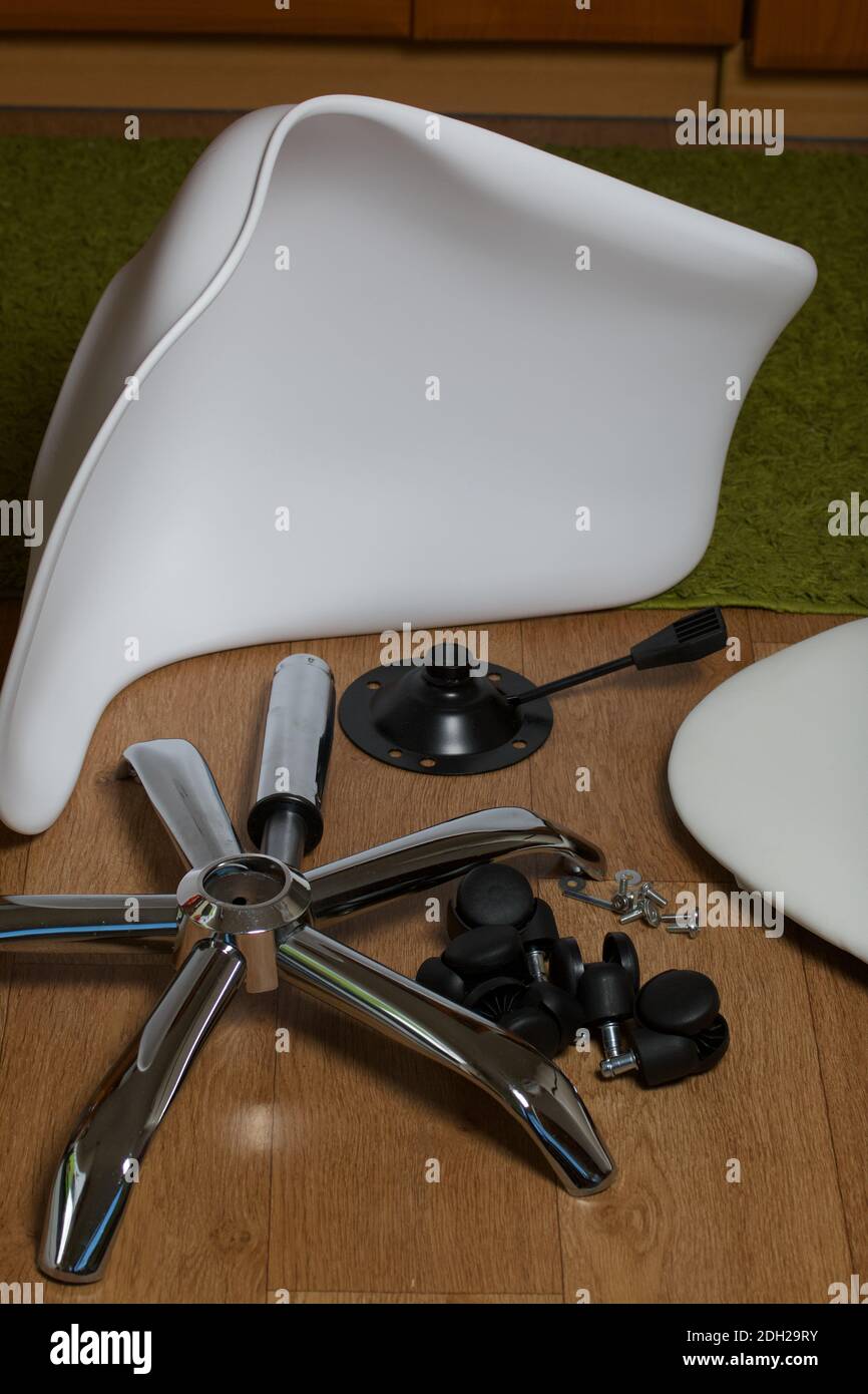 Dettagli della sedia da ufficio. Si trovano al piano dell'appartamento. Montaggio di una sedia per computer su ruote. Foto Stock