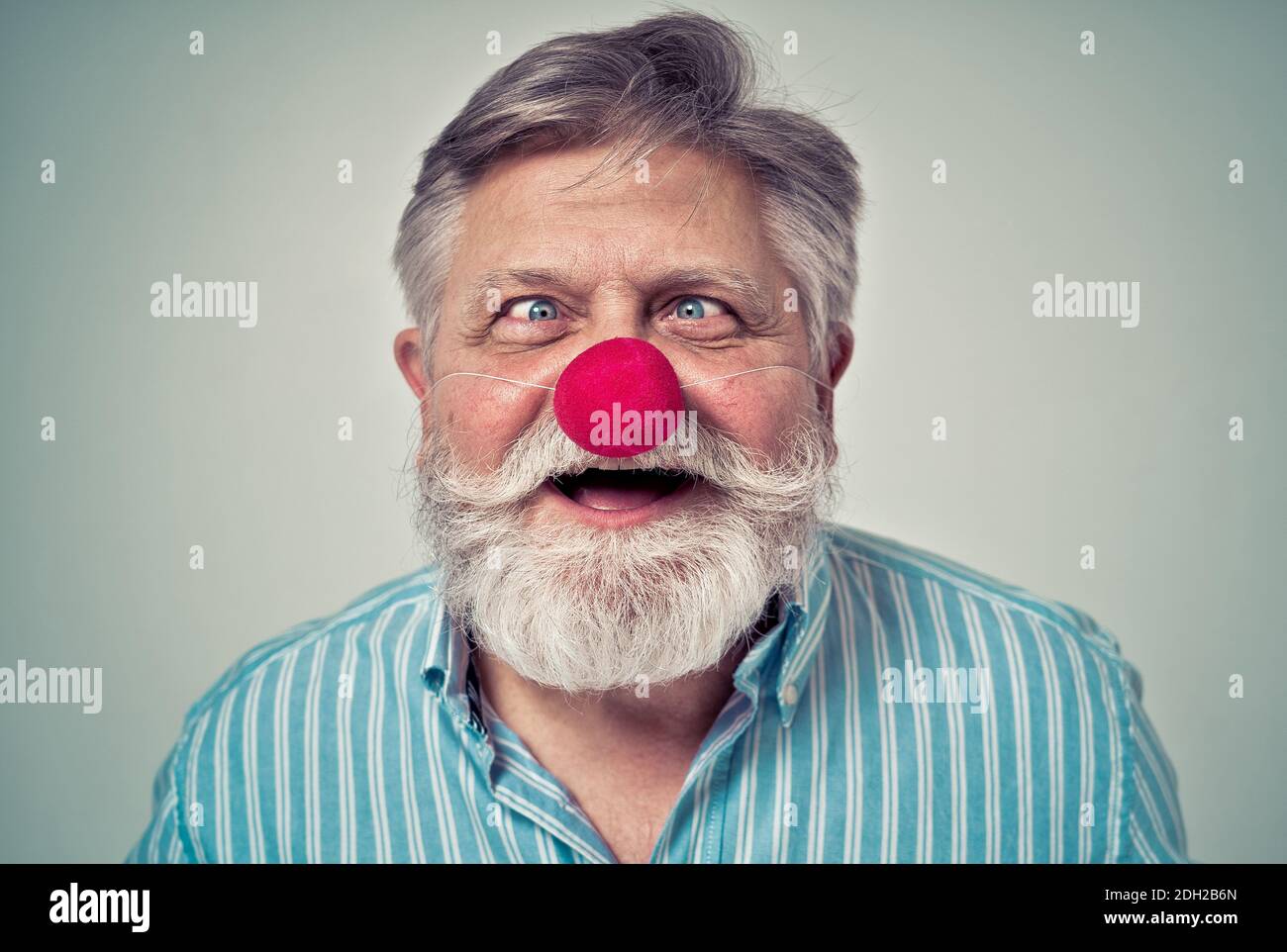 Uomo anziano divertente che posa in un photoshooting. Hipster felice facendo espressioni divertenti. Concetto di persone e stile di vita. Foto Stock