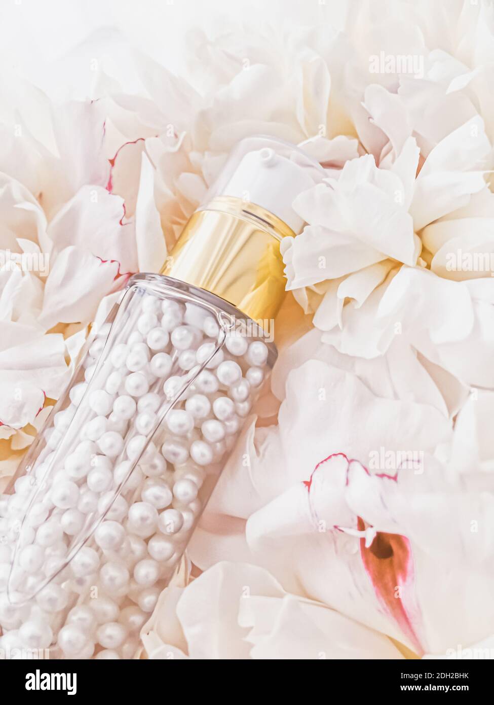 Lussuosa bottiglia cosmetica come prodotto anti-invecchiamento per la cura della pelle su sfondo di fiori, confezione con etichetta vuota per la cura del corpo Foto Stock