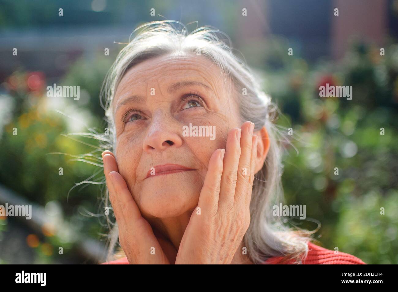 Ritratto di una donna matura con capelli grigi che trascorre il tempo all'aperto durante il giorno di sole, pensionamento felice Foto Stock
