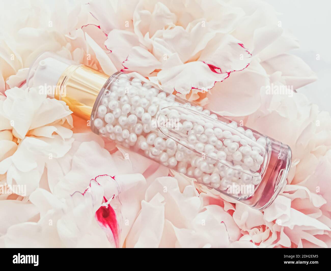 Lussuosa bottiglia cosmetica come prodotto anti-invecchiamento per la cura della pelle su sfondo di fiori, confezione con etichetta vuota per la cura del corpo Foto Stock