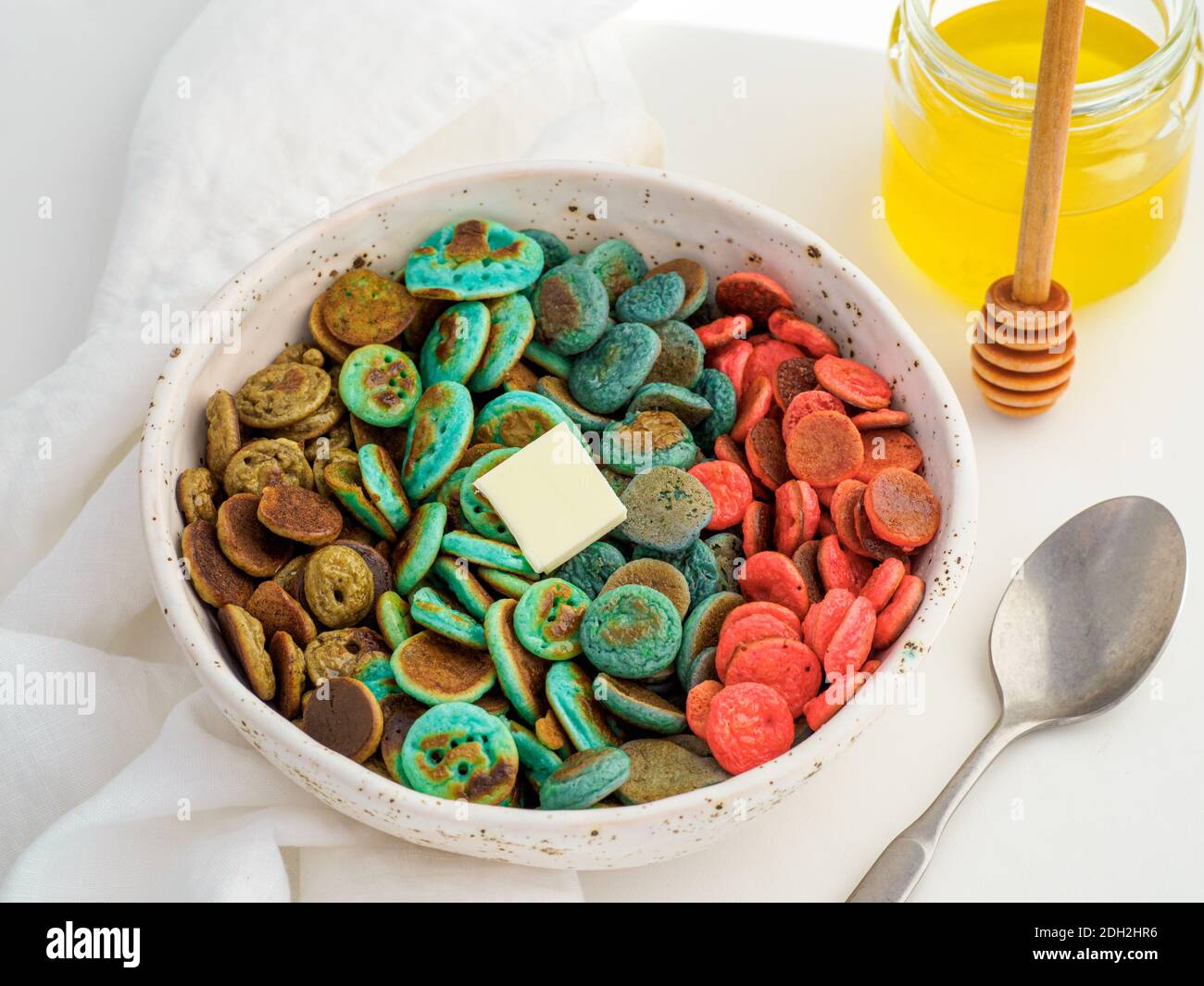 Cereali con frittelle colorate nelle mani del bambino Foto Stock