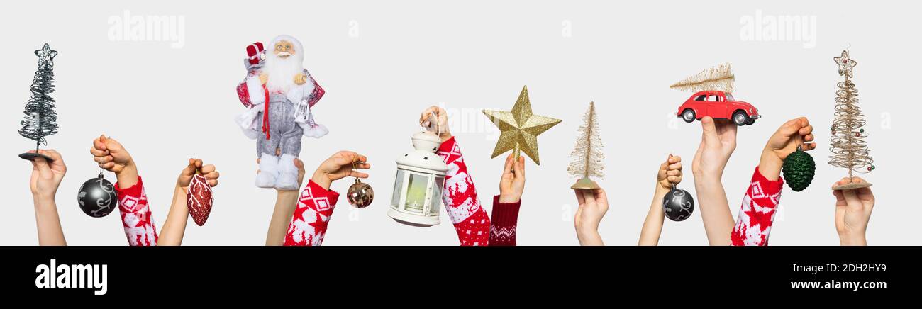 Giocattoli di Natale nelle mani sul bianco Foto Stock
